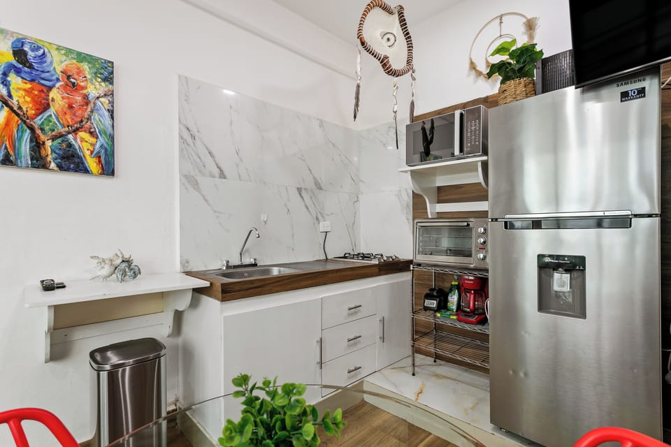 El área de la cocina cuenta con cafetera, refrigerador, microondas, estufa.