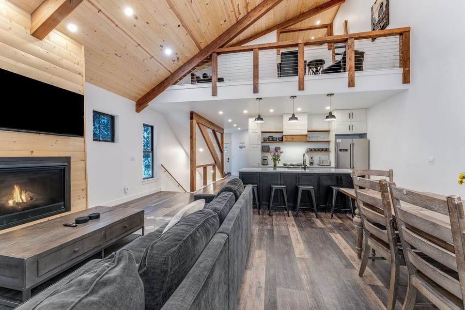 Relax in your cozy living room where exposed beams meet modern comfort, while the crackling fireplace warms memorable evenings together.