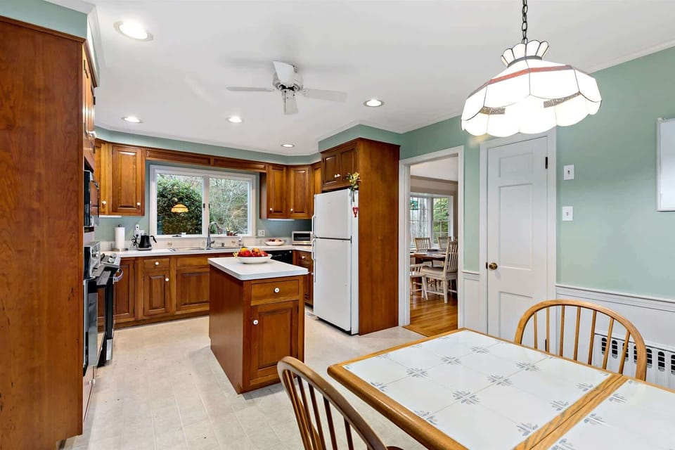 Spacious Cape Cod kitchen with island seating, stainless appliances, and window over sink, perfect home base near Long Pond