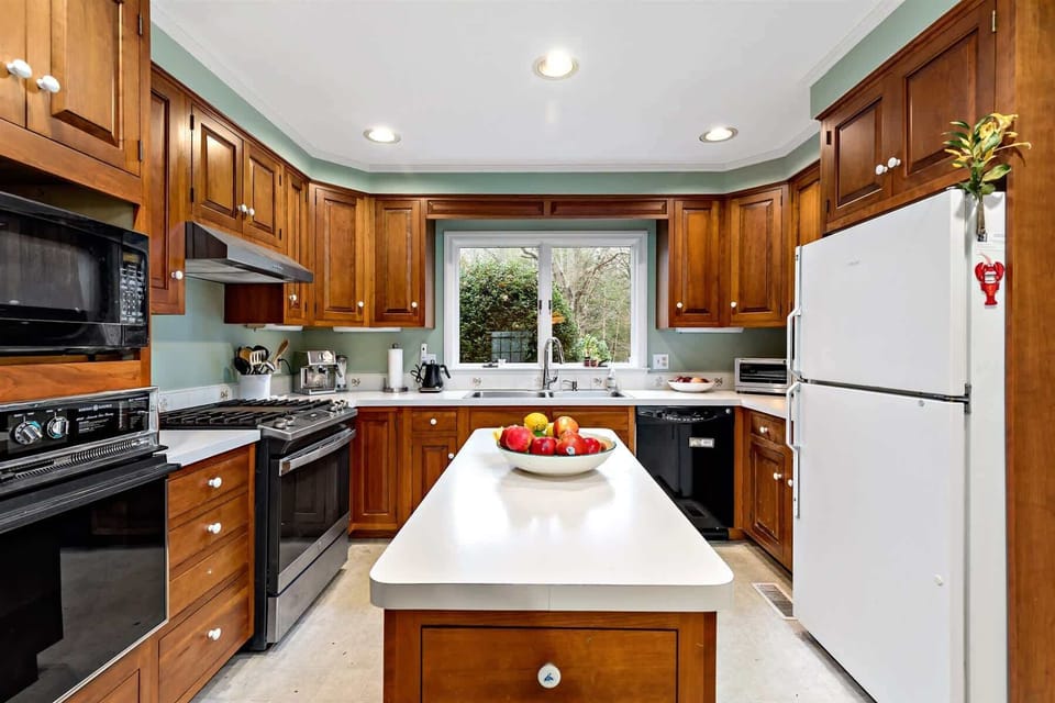 Clean, bright kitchen view with prep island, abundant cabinetry, and breakfast area