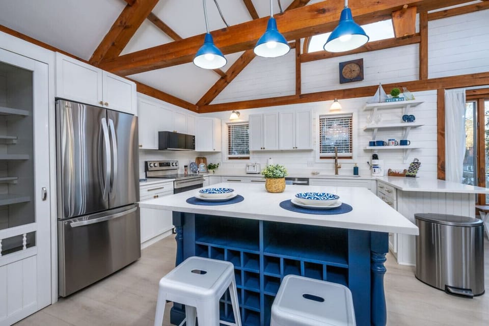 Another view of the kitchen. Gather around the oversized island, perfect for casual meals, cocktails, and planning the day. Bright, fully stocked, and designed so everyone can cook, snack, and connect at once.