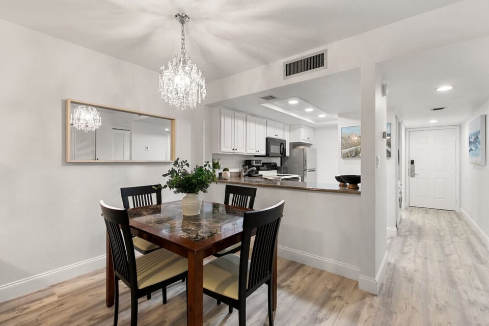 This well lit dinning room offers a kitchen table with 4 chairs and views of the kitchen.