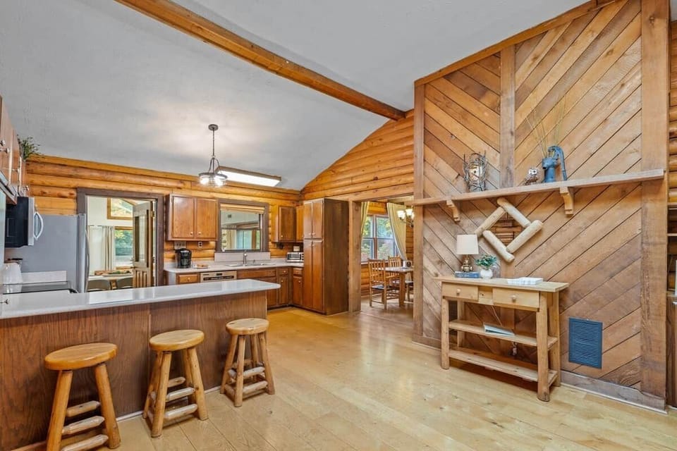 Open-concept kitchen and dining area featuring classic log walls, ample counter space, and seamless flow for group meals.