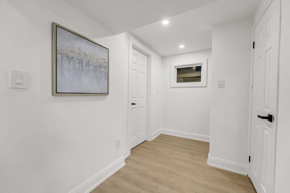 Bright and clean hallway area with modern artwork, guiding you into the main living spaces. This area maintains the home`s contemporary aesthetic.