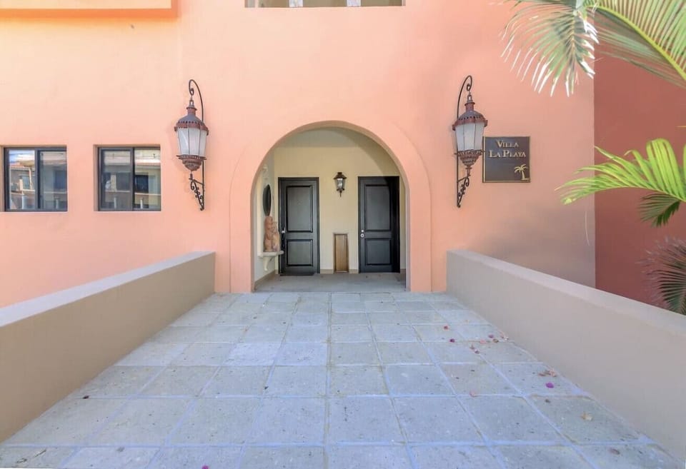 Grand arched entrance to Villa La Playa with classic Mediterranean charm.