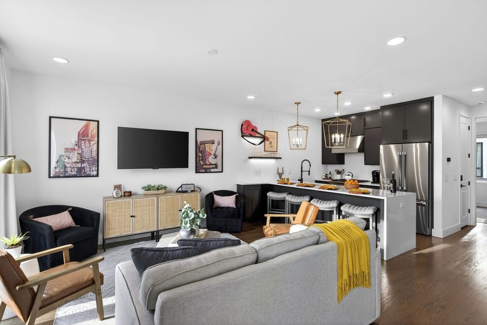 A bright, inviting living area with a queen sleeper sofa and large windows that bring in natural light.