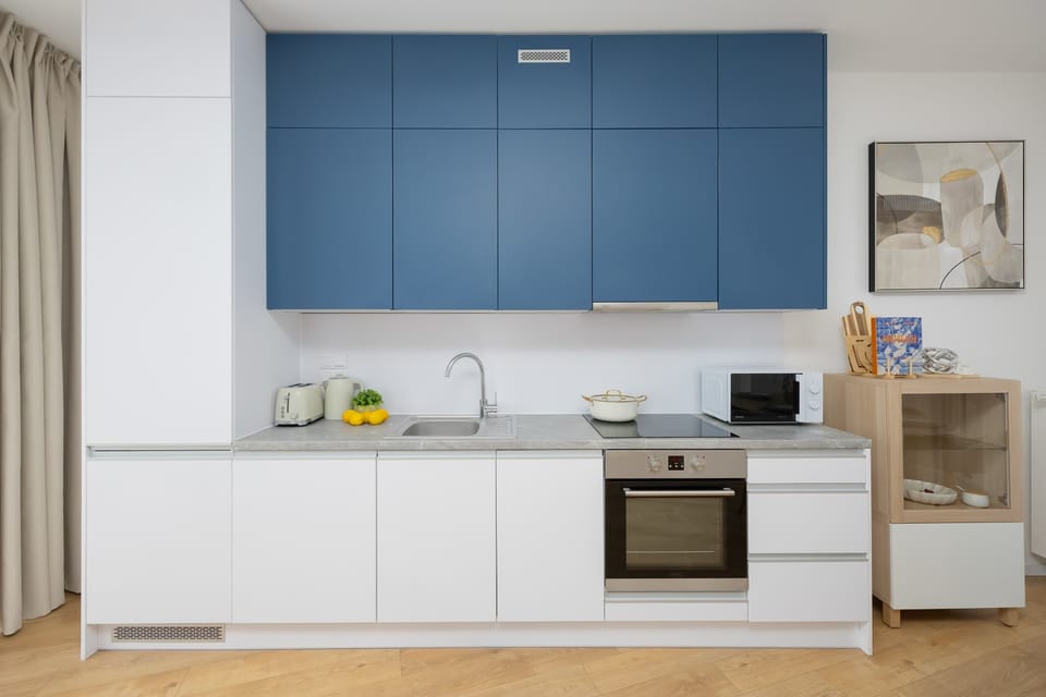 Modern kitchen with blue cabinets and built-in appliances.