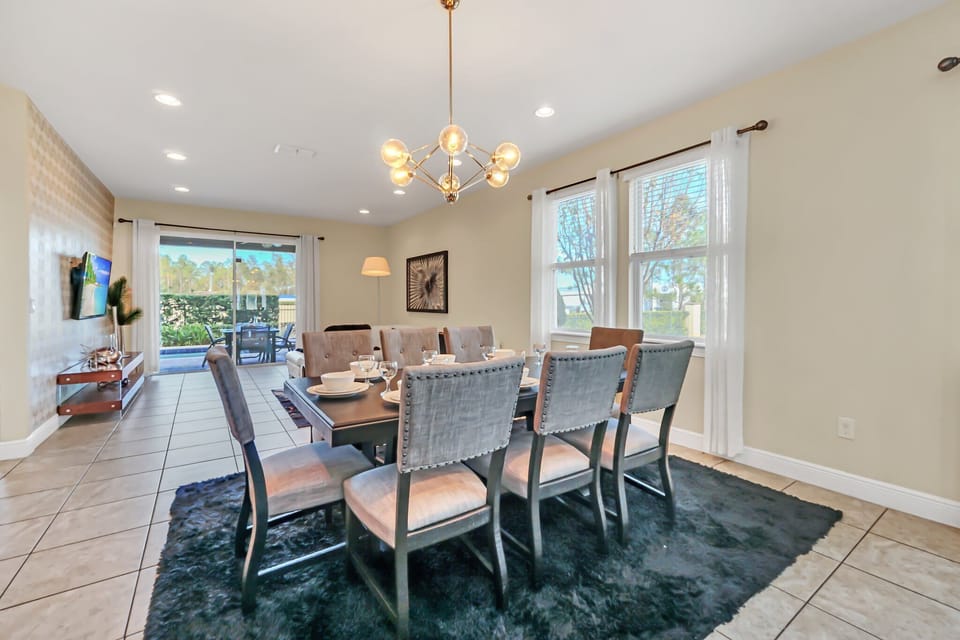 Modern dining area with seating for eight and natural light from large windows.
