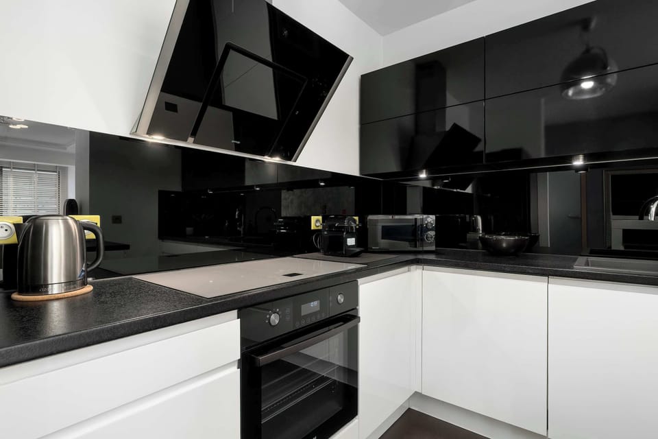 The kitchen from a different angle highlighting the clean, modern design and black-and-white contrast.
