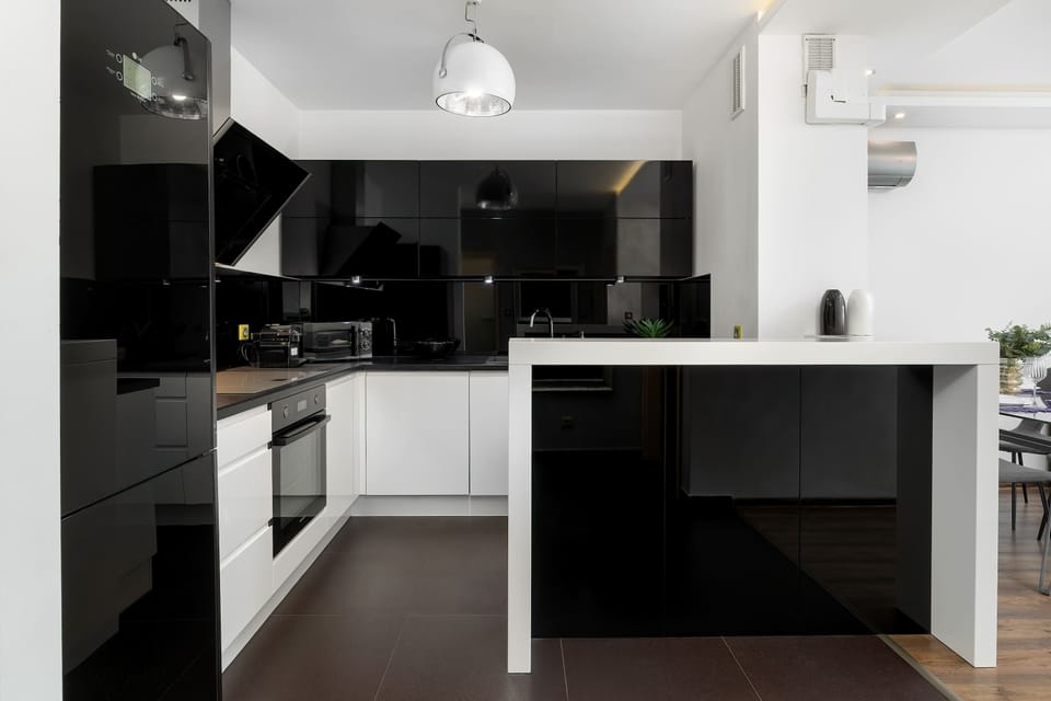 Another view of the kitchen showing the sleek cabinetry, built-in oven, and induction cooktop.