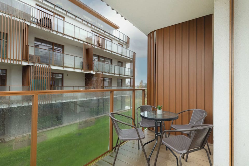 A different view of the balcony area showing greenery and building facades. The space is ideal for quiet moments outdoors.