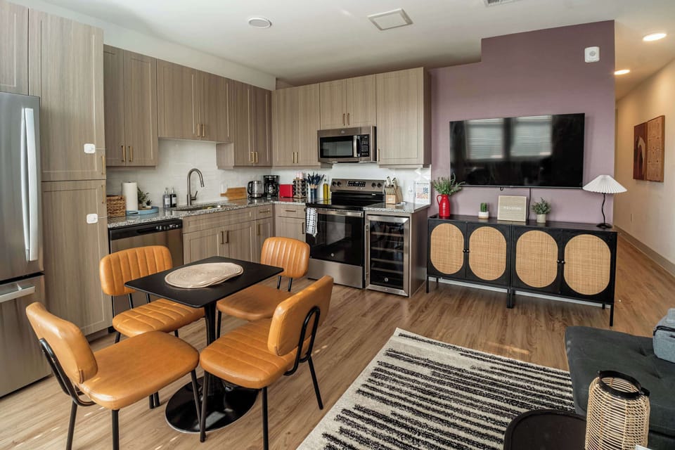 Spacious kitchen and dining area with modern appliances, ample counter space, and stylish seating. Perfect for preparing meals at home, enjoying takeout, or gathering for casual breakfasts before heading out.
