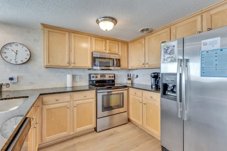Your fully equipped kitchen features stainless steel appliances and warm wood cabinets, perfect for preparing meals during your stay.