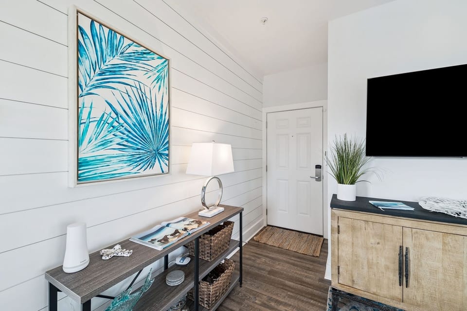 Relax in your bright living space with tropical artwork, entertainment center, and thoughtful coastal touches throughout.