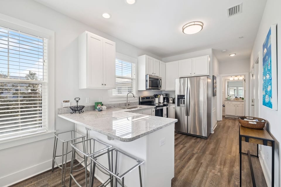 Step into your bright, modern kitchen with granite countertops, stainless steel appliances, and a breakfast bar perfect for morning coffee.