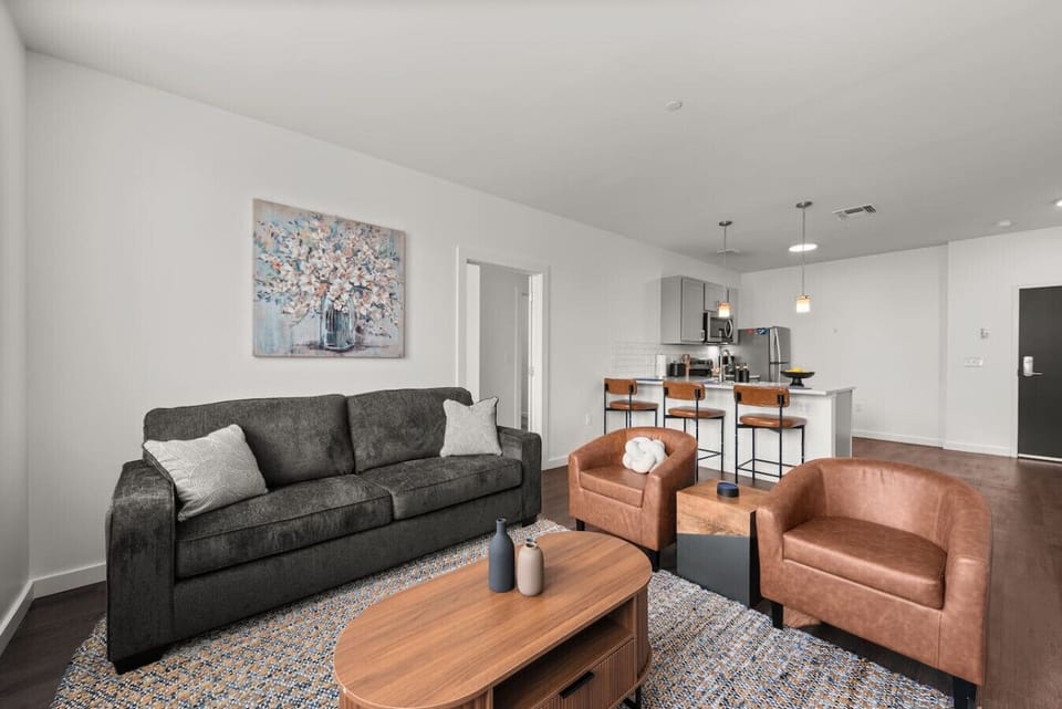 Comfortable living room with sofa, accent chairs, and open kitchen