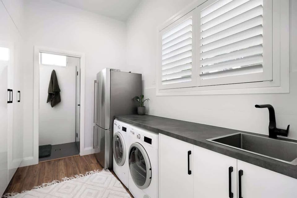 Spacious laundry with Bosch washer (that has a smart iDose function where the detergents are preloaded. Bosch dryer, iron, ironing board, second entertaining fridge. Here there is also the second bathroom with shower and toilet. 