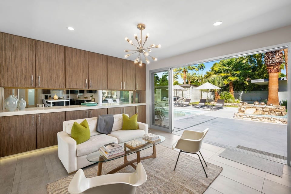 Inviting open lounge space just off the kitchen, perfectly positioned between the large sliders to the pool and the dining room. A great spot to relax, gather with friends, or enjoy the indoor outdoor flow of the home.