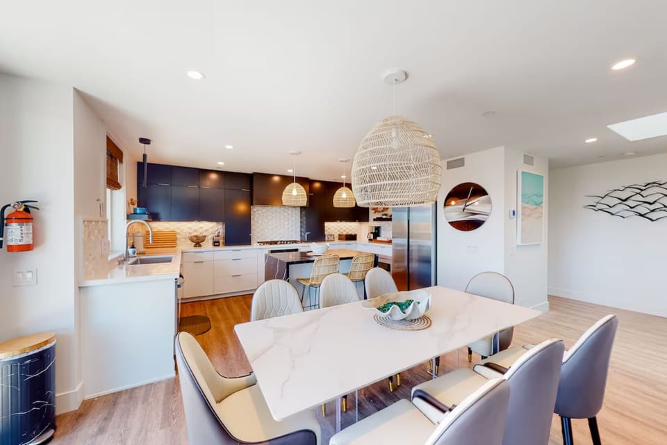Enjoy meals together at this stylish dining area with contemporary seating and easy access to the kitchen. Perfect for family dinners, game nights, or planning your next beach adventure just minutes from the ocean.