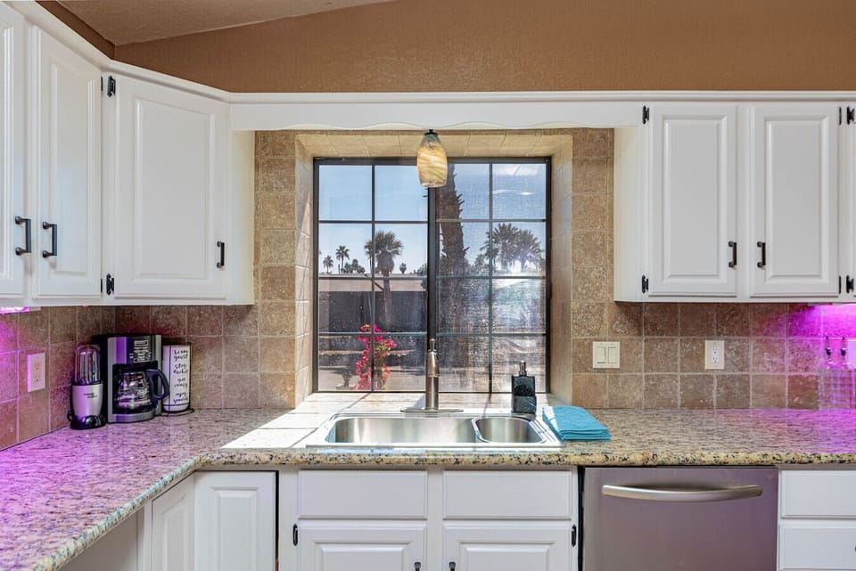 Bright, fully stocked kitchen with granite countertops, coffee bar, and plenty of prep space for group meals.