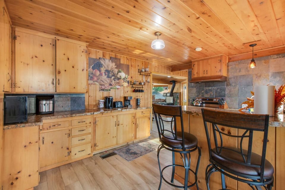 Fully equipped kitchen with stainless steel appliances and counter seating for 2.