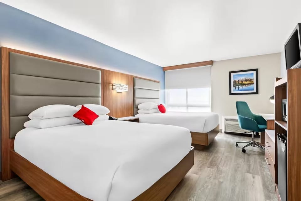 Unwind in bright double-queen comfort with crisp hotel linens.