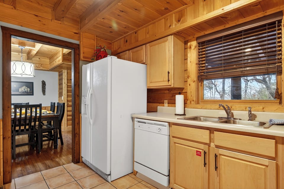 Kitchen view highlighting the full-sized refrigerator and pantry space.