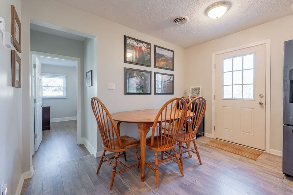 Enjoy meals or morning coffee in this bright, cozy dining nook with charming wall art and natural light.