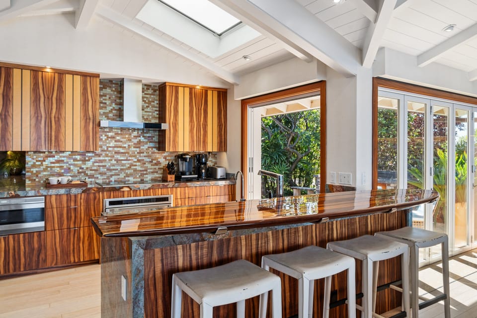 Dine casually at the bright kitchen counter with views of lush palms and open skies