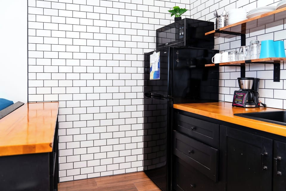 Your compact kitchenette comes equipped with everything you need: a full-size fridge, microwave, coffee maker, and ample counter space to prepare quick meals or morning coffee.