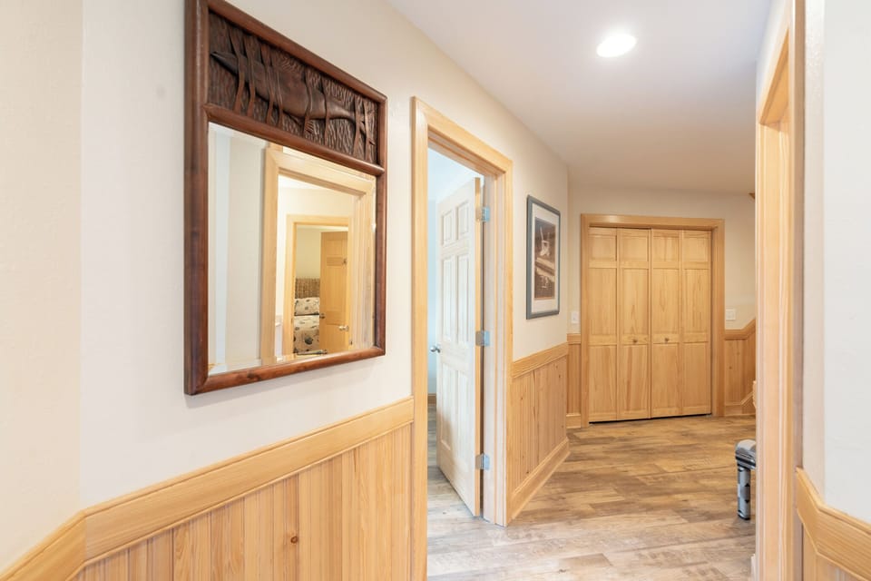 Step into your welcoming hallway, where warm wood wainscoting and thoughtful touches create an inviting atmosphere for your mountain getaway.