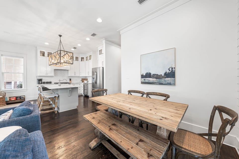 Your open-concept living flows seamlessly from kitchen to dining, where rustic wooden tables invite family meals under elegant pendant lighting.