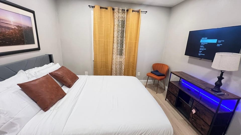Cozy queen bedroom with Smart TV, comfortable bedding, and modern décor