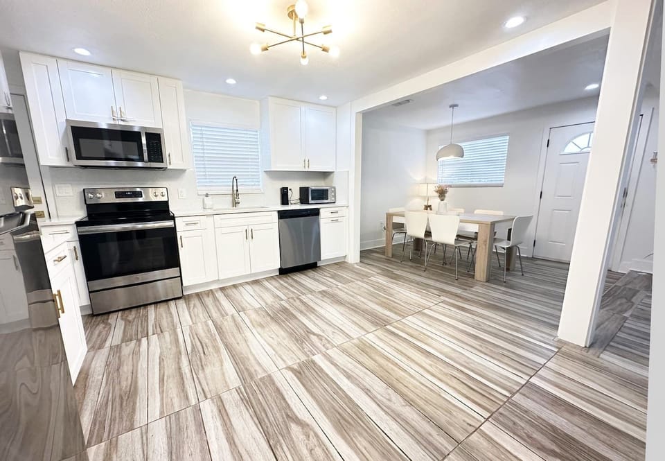 open space kitchen area included silverware, cookware and a coffee maker.