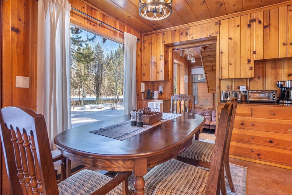 The wooden dining table provides ample seating for friends and family to gather around for a home cooked meal.