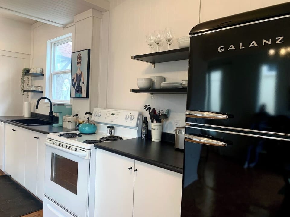 Fully equipped kitchen with stove, microwave, coffee maker, cookware, and dining essentials.