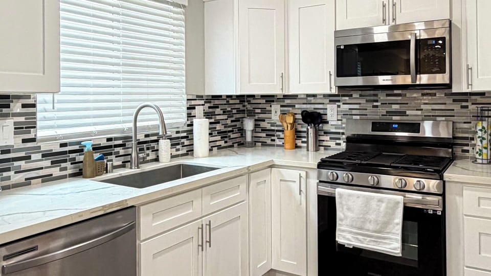 Modern kitchen with white cabinets, stainless appliances, and spacious island.