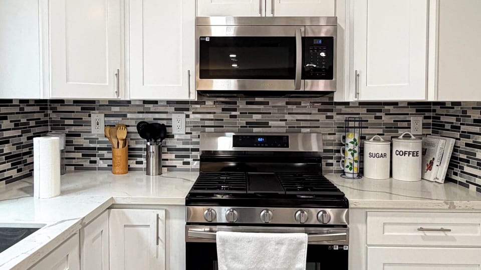 Modern kitchen with white cabinets, stainless appliances, and spacious island.