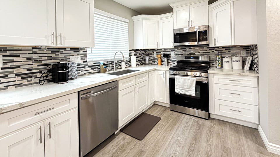 Modern kitchen with white cabinets, stainless appliances, and spacious island.