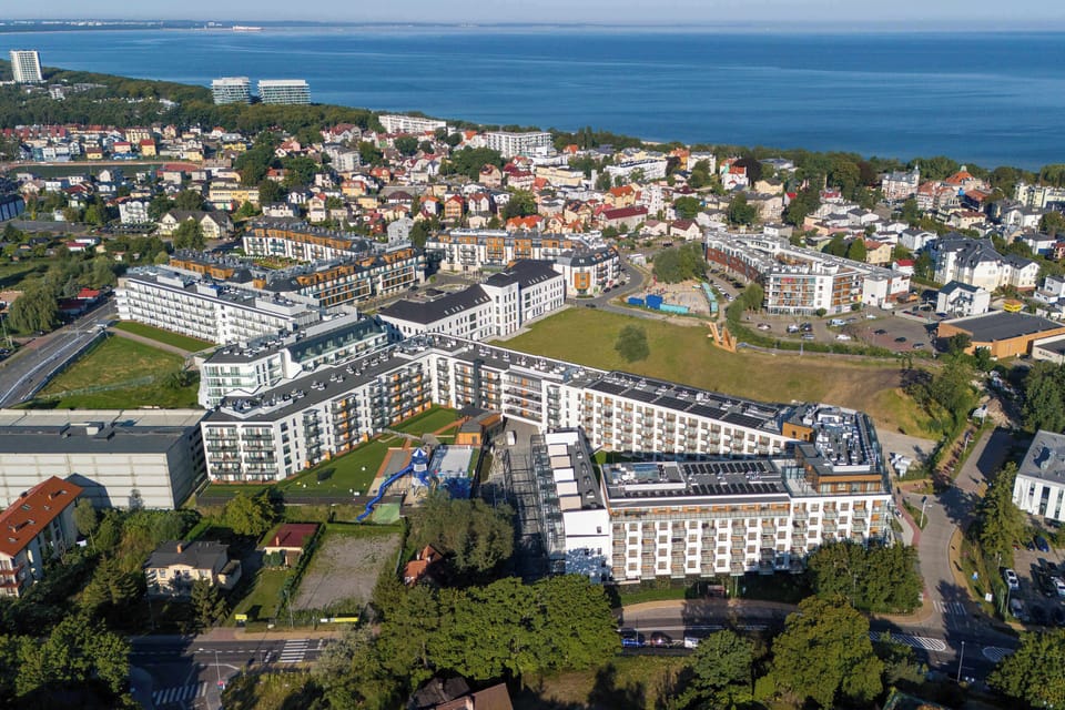 An aerial view of the apartment complex near the seaside. The location highlights proximity to the coast.