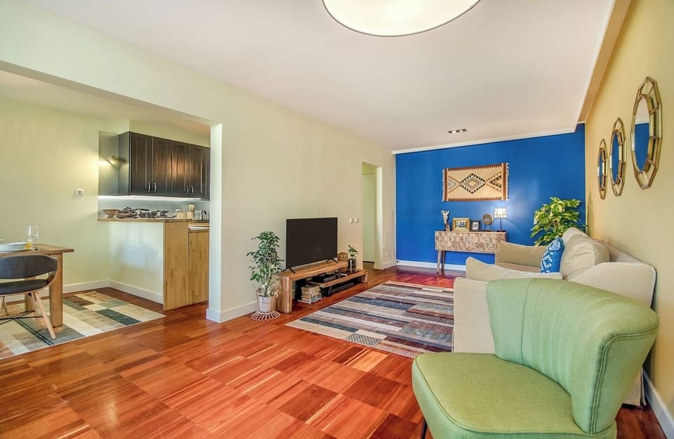 Living Room with TV that opens onto the balcony. The full length windows allow the light to brighten up the space.