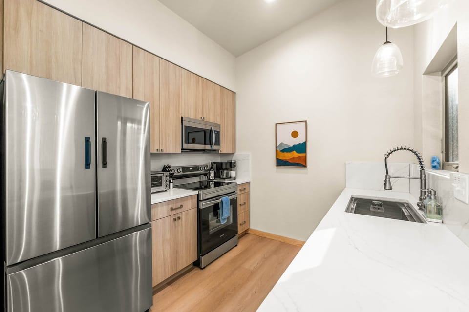 The kitchen features brand new stainless steel appliances.