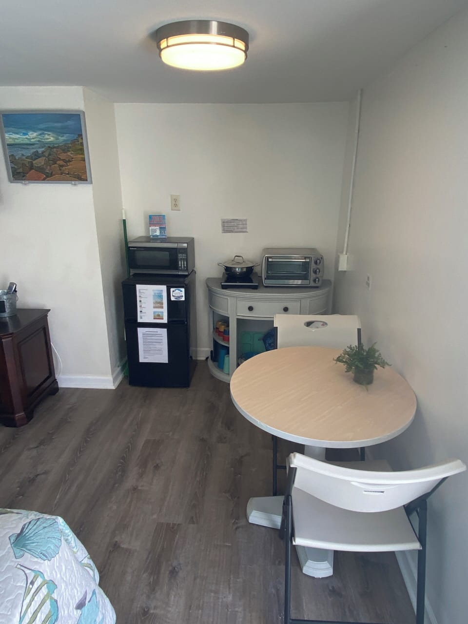 Your stylish kitchenette awaits with modern appliances, dining table for two, and thoughtful touches like fresh greenery to make meals memorable.