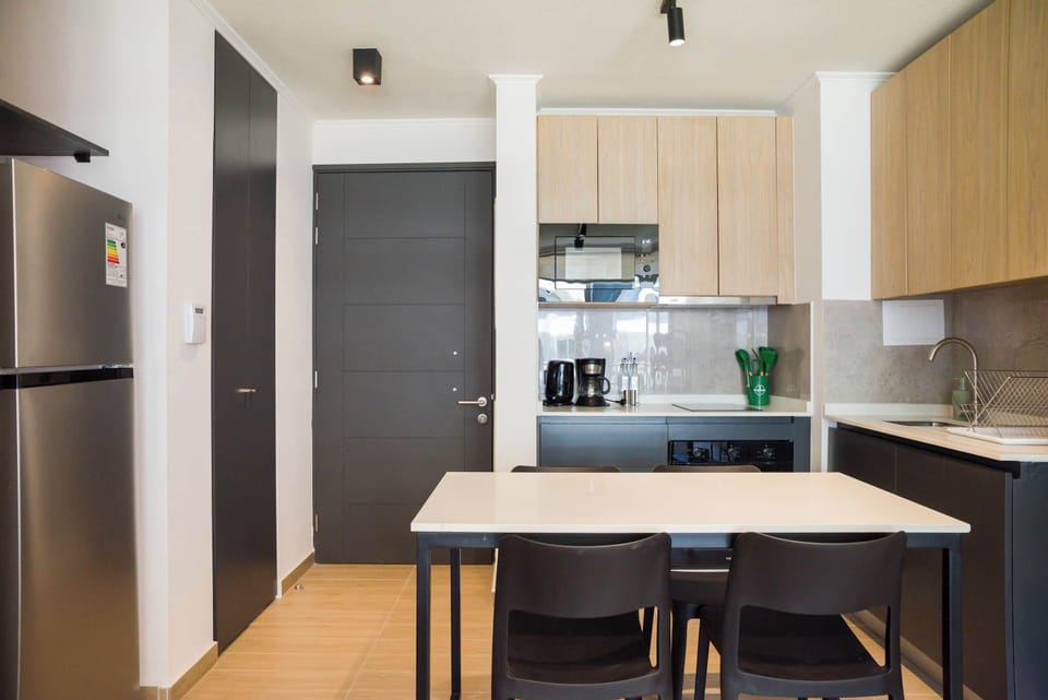 Modern kitchen with sleek appliances and cozy dining area, perfect for enjoying home-cooked meals.