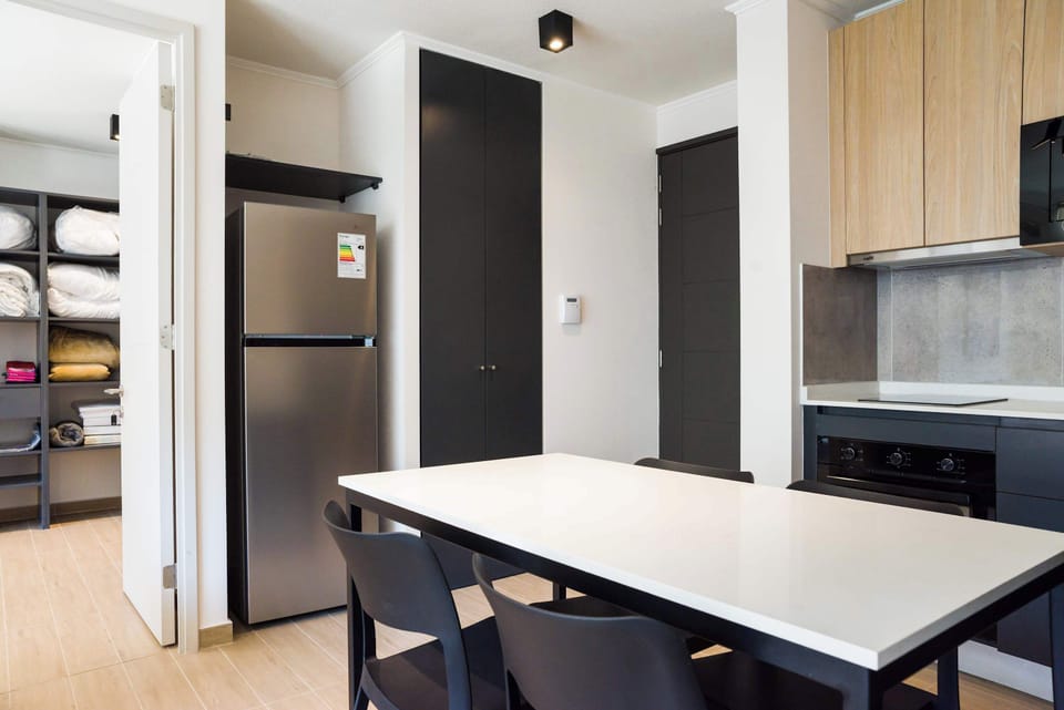 Modern kitchen with sleek design and ample storage, perfect for culinary adventures in your cozy Chilean apartment.