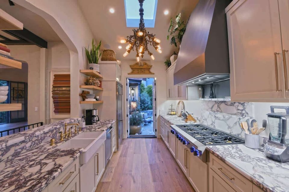 Kitchen area with a 20-foot ceilings, skylights, Italian marble countertops