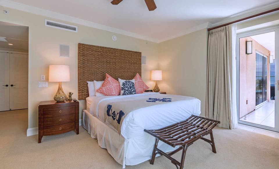 Comfortable master suite with coastal decor and direct access to lanai for peaceful morning views. HKK-450