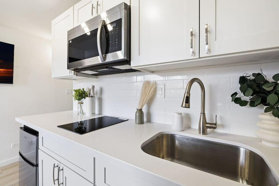 Kitchenette with induction cooktop, microwave, and kitchenware
