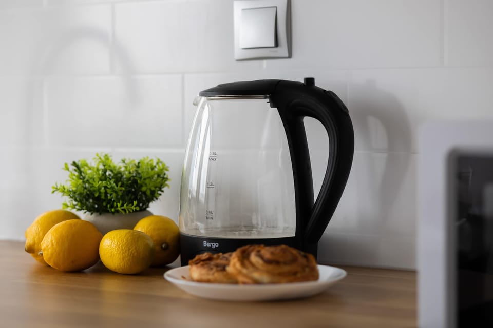 Kitchen counter with kettle and complimentary items.
