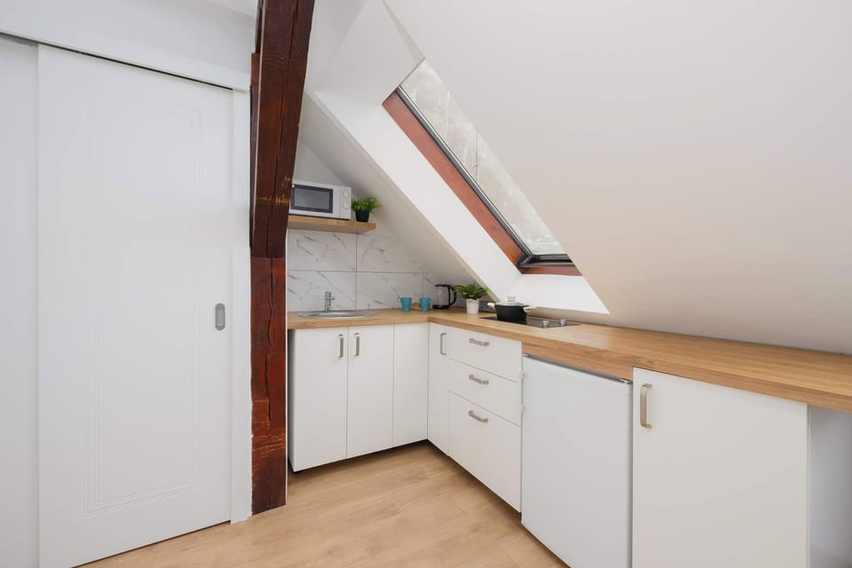A modern kitchenette with white furniture.